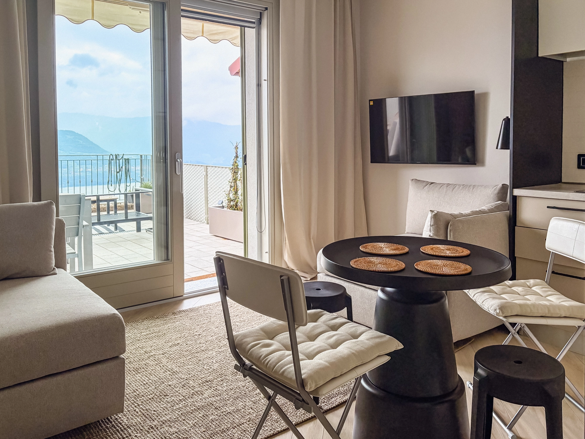 Salon apartamentu La Dolce Vista Iseo z otwartą kuchnią i widokiem na jezioro